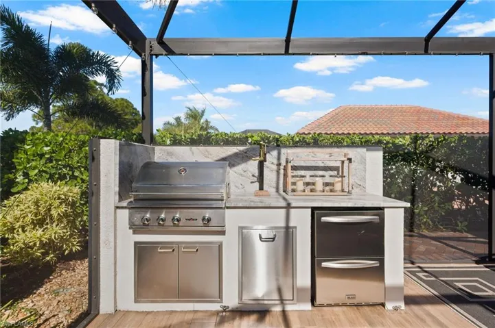 View of patio with an outdoor kitchen and a lanai