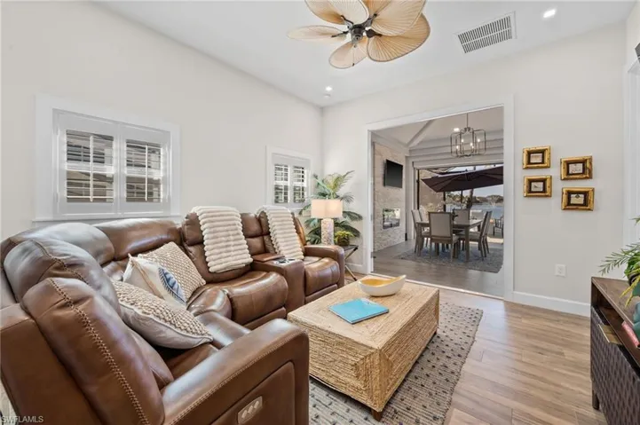 Living room with light wood-style floors, recessed lighting, a chandelier, and a ceiling fan