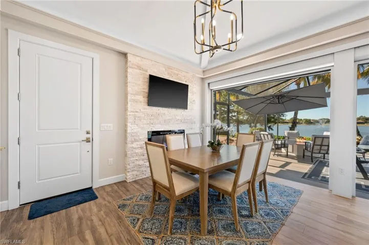 Dining area featuring a sunroom, wood finished floors, and a chandelier
