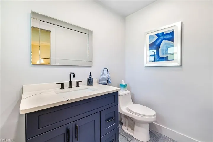 Bathroom featuring tile patterned flooring, toilet, vanity, and baseboards