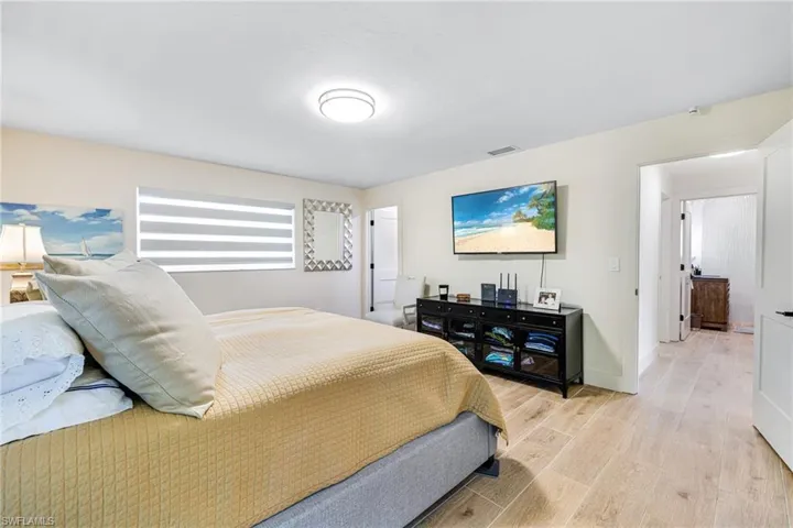 Bedroom with baseboards, light wood-style flooring, and visible vents