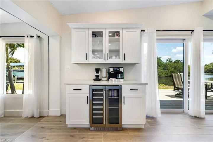 Bar with wood tiled floor, baseboards, a bar, and wine cooler