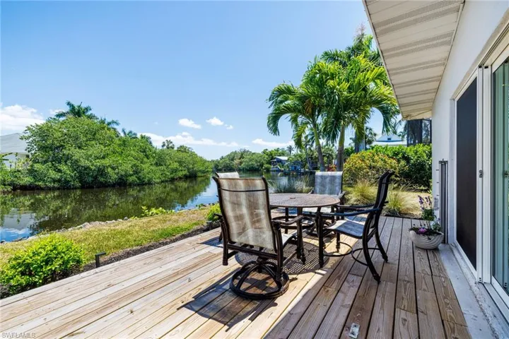 Wooden terrace with outdoor dining space and a water view