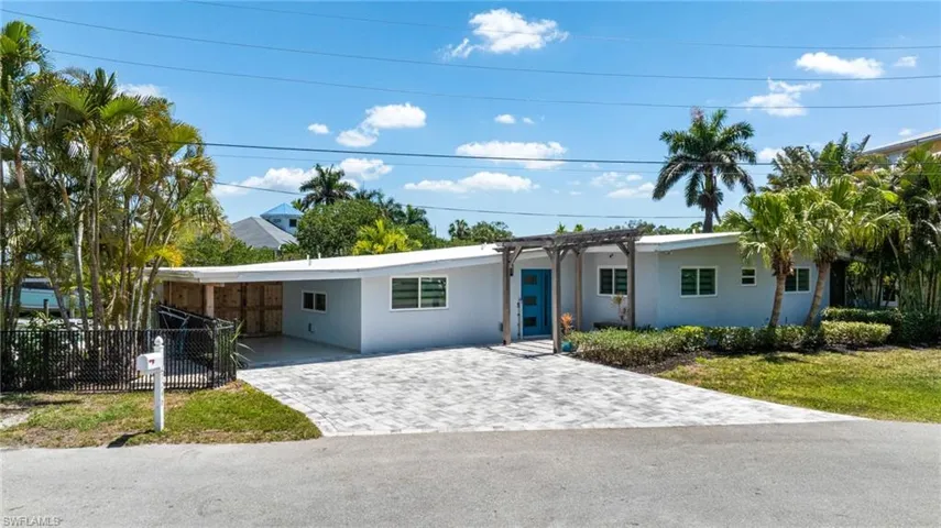 Ranch-style home with stucco siding, fence, decorative driveway, and a carport