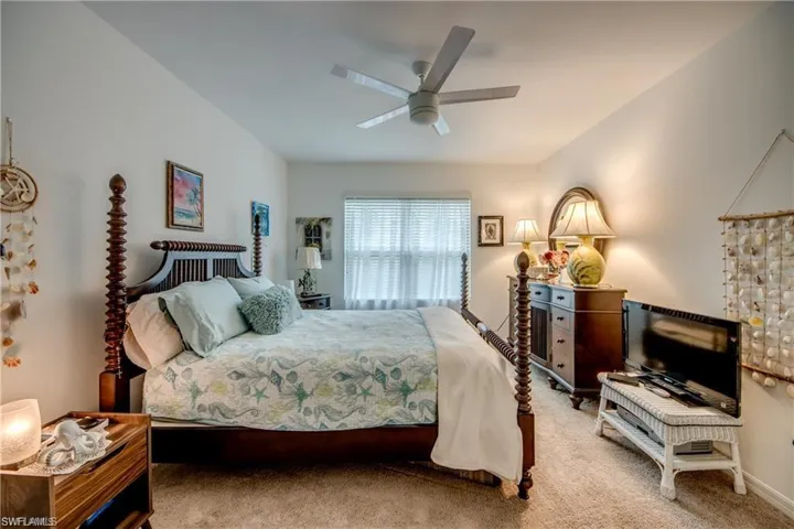 Carpeted bedroom with a ceiling fan