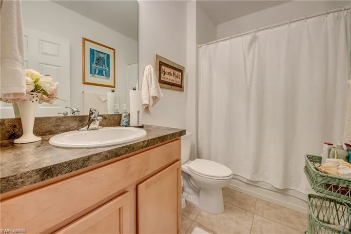 Bathroom featuring tile patterned floors, toilet, vanity, and shower / tub combo