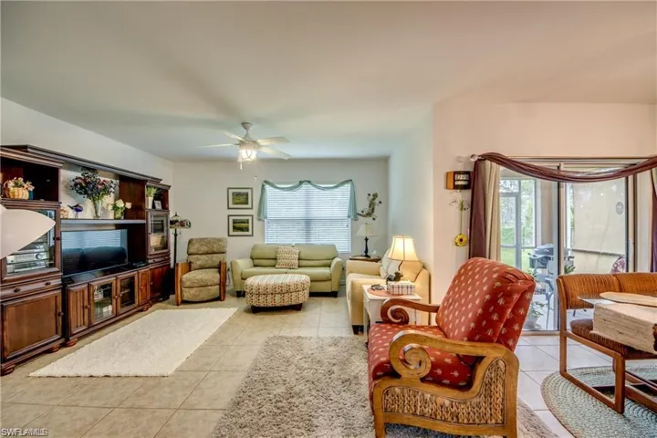 Living area featuring light tile patterned floors and ceiling fan