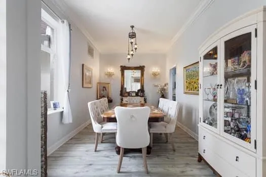 Dining space with light wood-style floors and ornamental molding