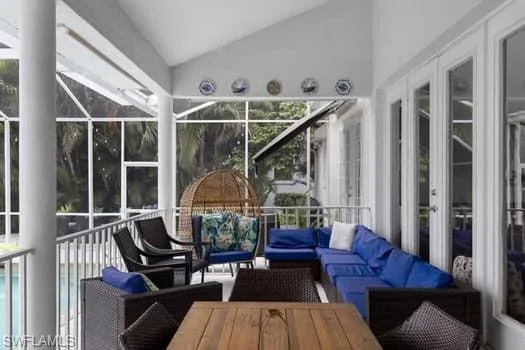 Sunroom / solarium with lofted ceiling, outdoor lounge area, and french doors