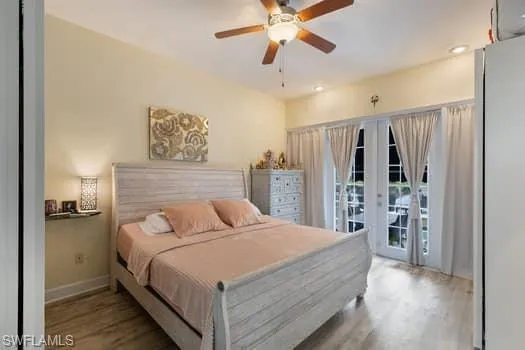 Bedroom featuring freestanding refrigerator, wood finished floors, access to exterior, ceiling fan, and recessed lighting