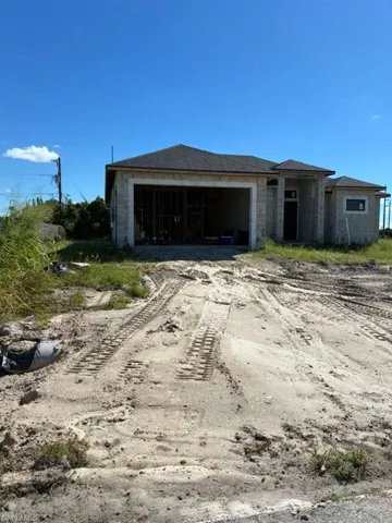 View of front of house featuring dirt driveway and stone siding