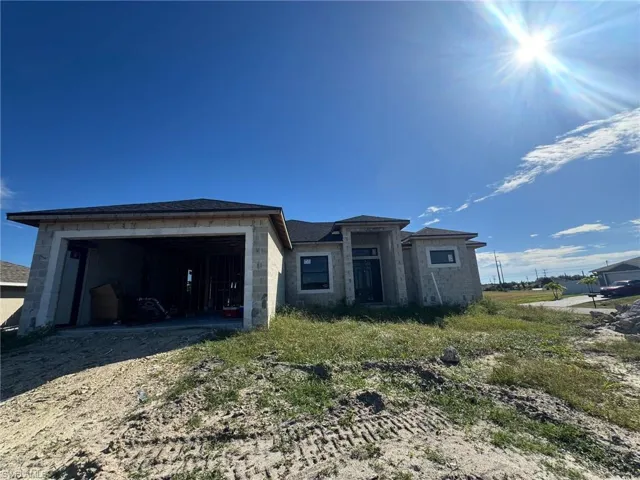View of front of property featuring dirt driveway and a garage
