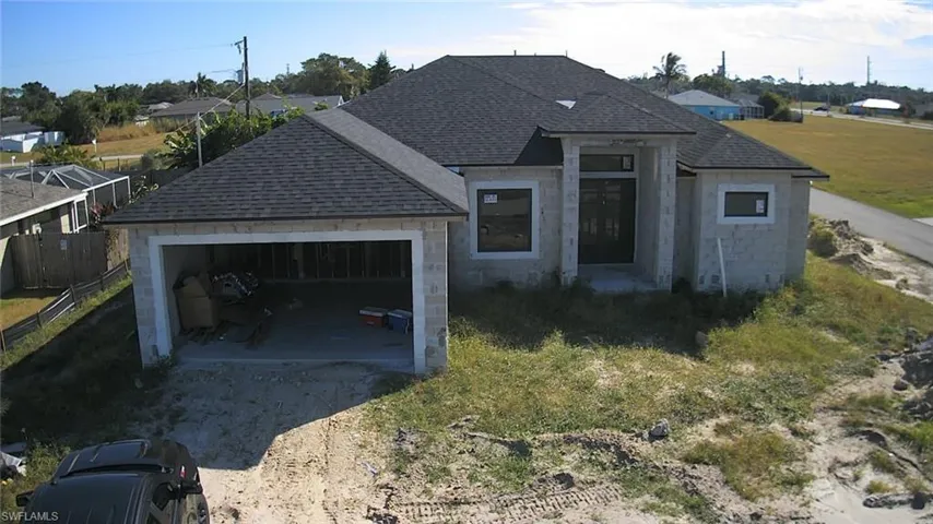 View of front of home with driveway, a shingled roof, and an attached garage