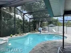 View of pool with a patio, a pool with connected hot tub, and screen enclosure