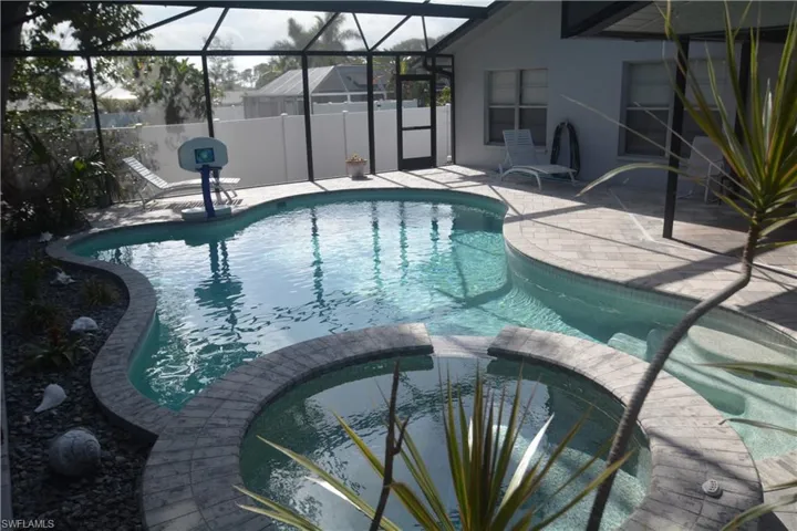View of pool featuring a patio area, a pool with connected hot tub, and a lanai