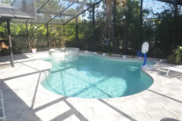 View of swimming pool featuring a pool with connected hot tub, a lanai, and a patio