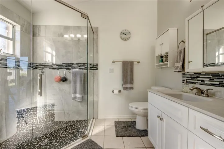 Remodeled Bath.  Fabulous walk in shower with stone floor, built in seat, Raised panel cabinetry with solid surface top and tile backsplash.