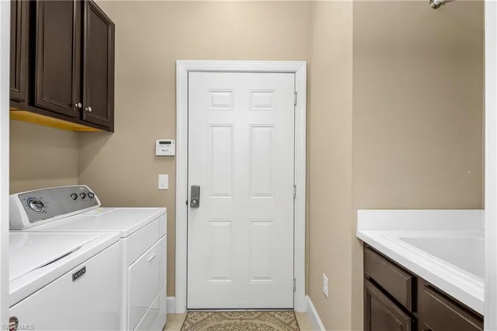 Laundry with utility sink and additional storage.