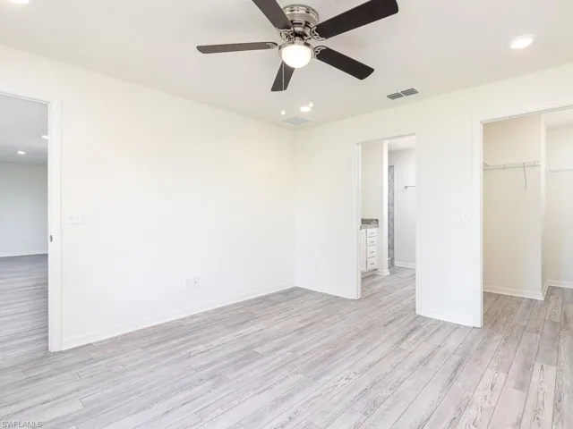Unfurnished bedroom featuring recessed lighting, light wood-style flooring, a spacious closet, and ceiling fan