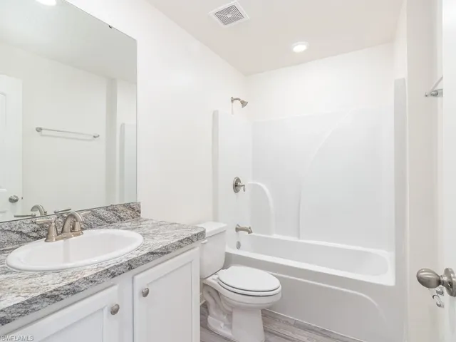 Bathroom with vanity,  shower combination, and light wood-type flooring