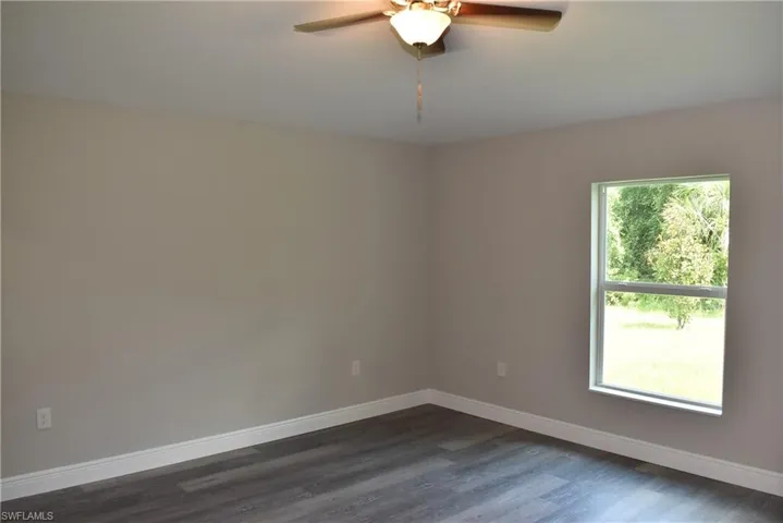 Empty room with ceiling fan and hardwood / wood-style flooring