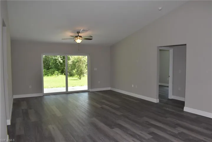 Spare room featuring hardwood / wood-style flooring, vaulted ceiling, and ceiling fan