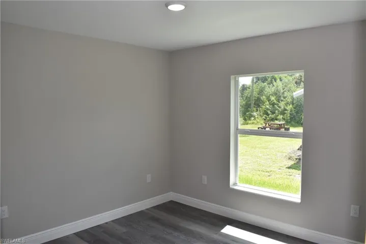 Spare room with dark wood-type flooring