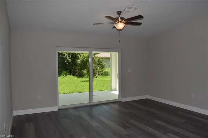 Unfurnished room with dark hardwood / wood-style floors and ceiling fan