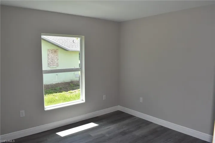 Unfurnished room with dark wood-type flooring