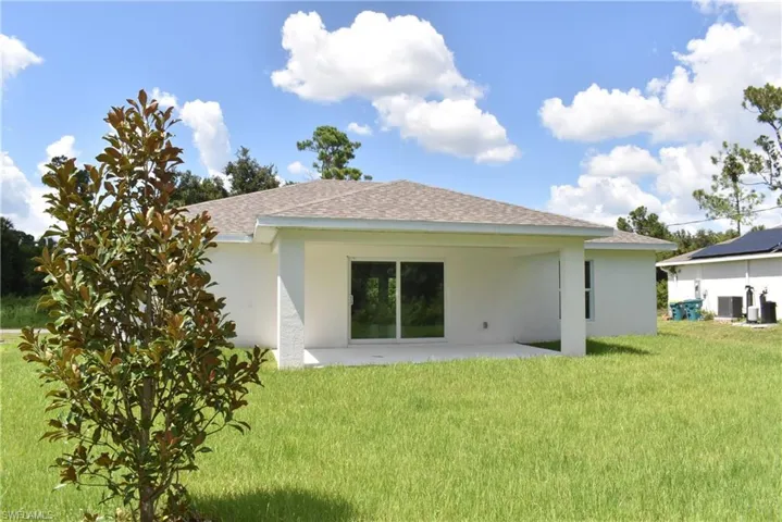 Rear view of house featuring a yard and a patio area