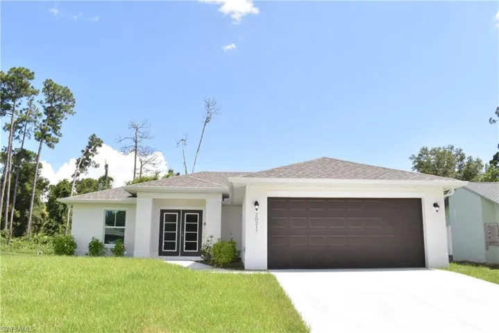 View of front of house with a garage and a front lawn