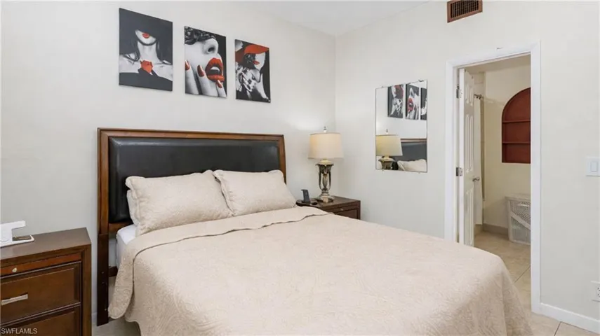 Bedroom with light tile patterned floors and ensuite bath