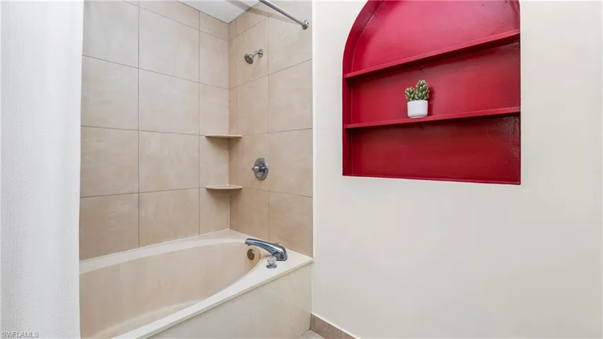 Full bath featuring shower / bath combo with shower curtain and built in features
