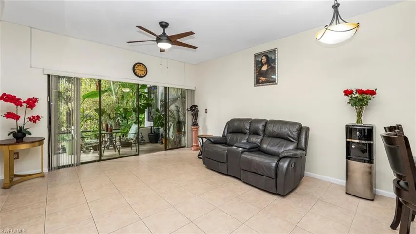 Living room with a ceiling fan and light tile patterned flooring
