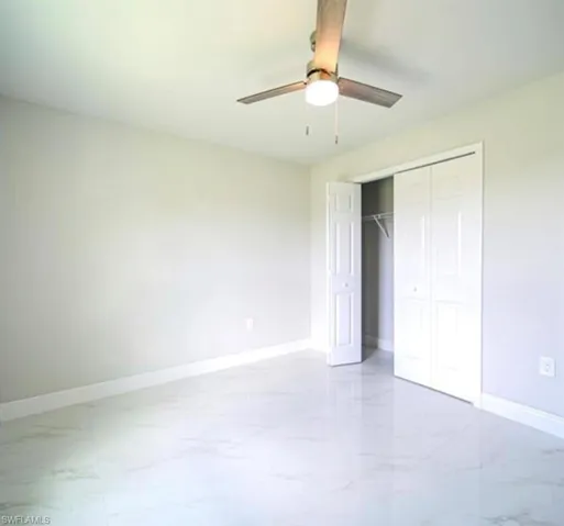 Room featuring light-toned walls and gleaming tile flooring