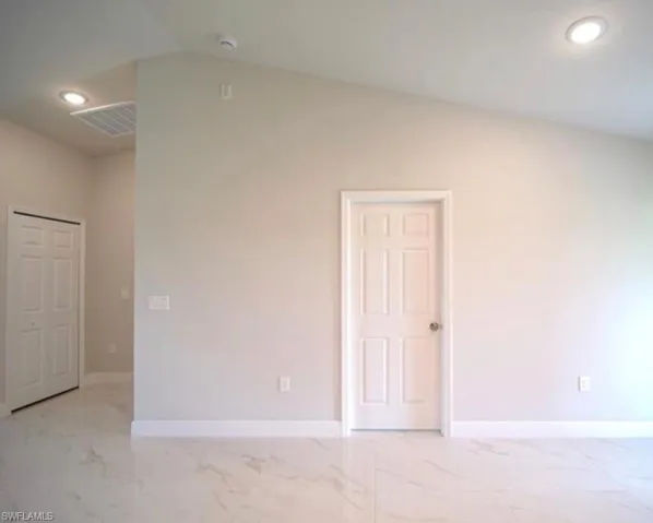 Vaulted ceiling with recessed lighting, complemented by white six-panel doors and white trim