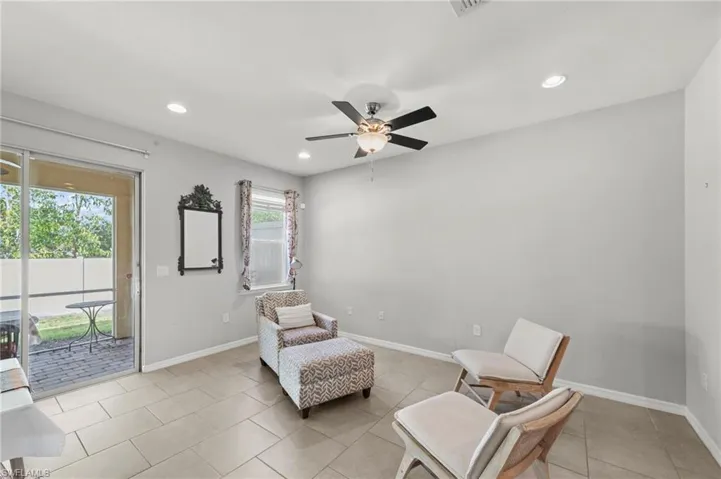 Living area with a ceiling fan, recessed lighting, and light tile patterned floors
