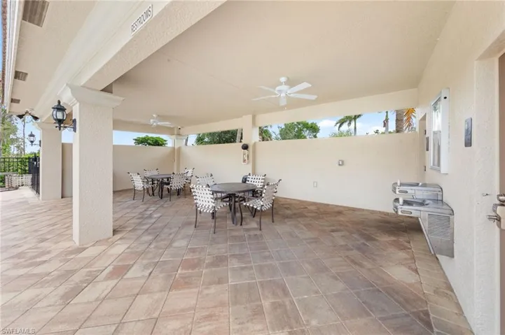 View of patio with outdoor dining area and ceiling fan