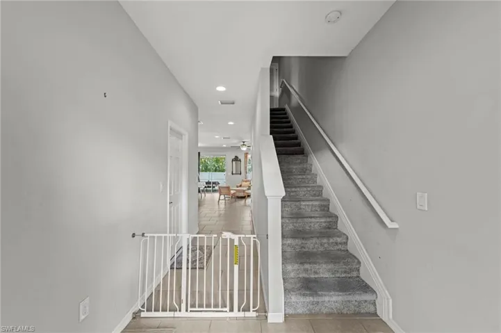 Stairway with tile patterned flooring, recessed lighting, and a ceiling fan