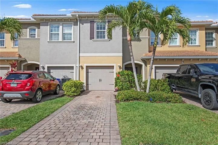 Mediterranean / spanish-style house with a tiled roof, decorative driveway, stucco siding, and a garage