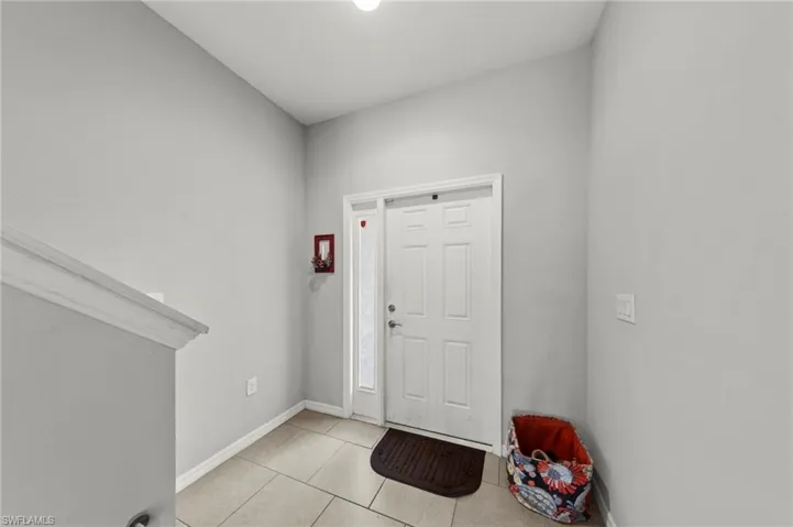 Entrance foyer featuring baseboards and light tile patterned floors