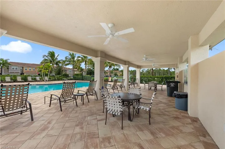 View of patio featuring a ceiling fan, a community pool, and outdoor dining area