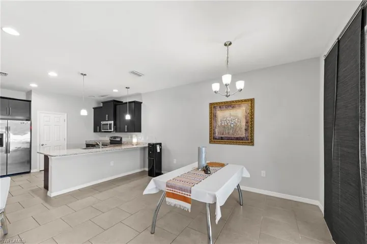 Dining area featuring hanging lights and light tile patterned floors
