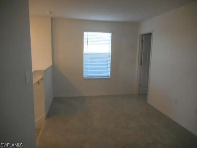 Carpeted empty room with baseboards