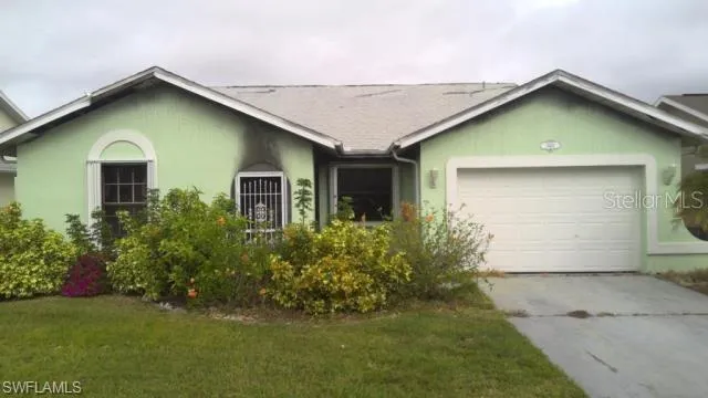 Single-story residence featuring a painted exterior, attached garage, and established landscaping
