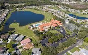 Community featuring a prominent body of water, a golf course, a swimming pool, and a large central building with multiple wings