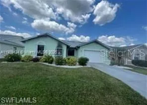 Single-story residence featuring a front-facing garage, a concrete driveway, and a well-maintained lawn