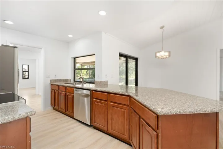 Kitchen featuring granite counters and a pass through window overlooking the backyard.