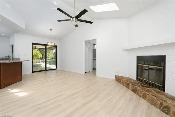 Located off the kitchen area, the Family Room has vaulted ceiling with skylight, ceiling fan with notable chandelier in eati-in/study area,  baseboards, Pergo floors, and a glass covered fireplace. Split bedroom design with guest bath and bedrooms off to the right.