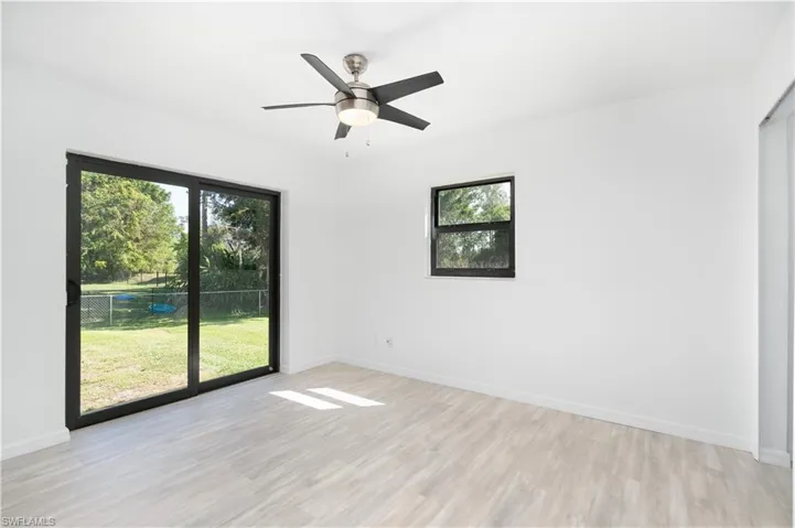 Bedroom 1 with ceiling fan, Pergo flooring, and baseboards. Ample closet space. Windows add lots of light. Freshly painted interior.